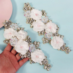 Detailed view of handmade 3D floral appliques with rhinestones and sequins for bridal gowns