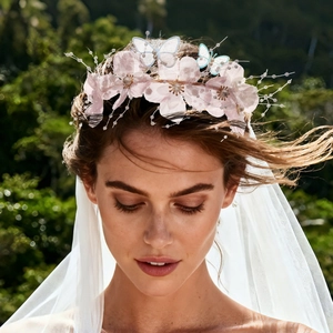 Detail of pink fabric flowers and delicate butterfly ornaments on a bridal headband