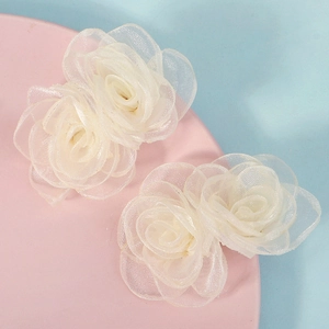 Vue détaillée des barrettes à fleurs en organza blanc avec texture en maille délicate