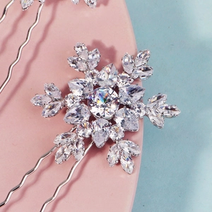 Macro shot of sparkling zircon snowflake hair pins with U-shaped silver metal wave design