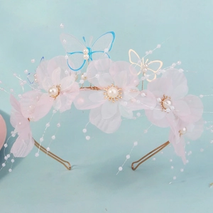 Elegant floral headband with pink mesh flowers, blue butterflies, and pearls on gold frame