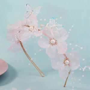 Close-up of pink chiffon flower headband with delicate pearls and mesh butterfly detail