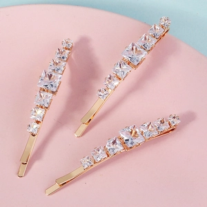 Detailed macro view of three gold-tone sparkling crystal hairpins for party styling