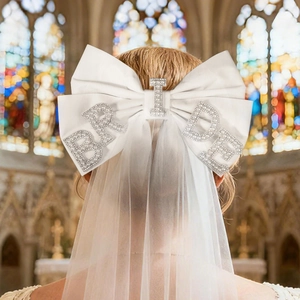 Detailed view of white bridal bow veil featuring pearl BRIDE lettering for weddings