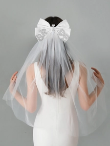 Detailed view of bridal bow veil with white satin ribbon and rhinestone BRIDE lettering