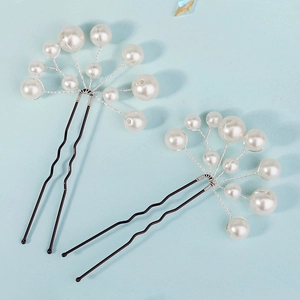 Detail view of two handcrafted U-shaped hairpins with white pearls and dark wavy metal pins