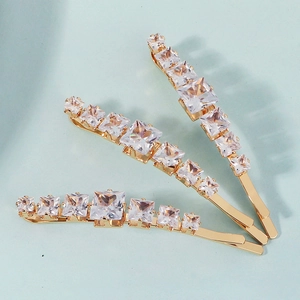 Detail view of gold-tone hair pins featuring gradient square zircon stones for women