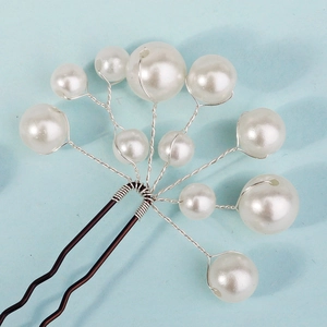 Close-up of handmade pearl U-shaped hairpin with intricate silver wire weaving details