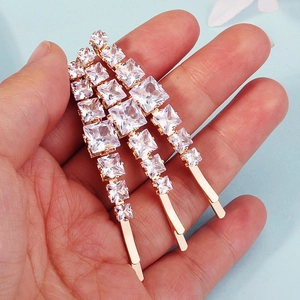 Detailed close-up of three rose gold hair pins with sparkling square-cut crystals
