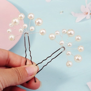 Detail of two handmade U-shaped hairpins with elegant white pearls and silver wire floral cluster