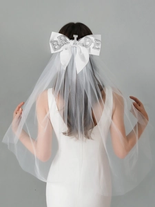 Close-up of bridal veil with large white bow and BRIDE rhinestone lettering detail