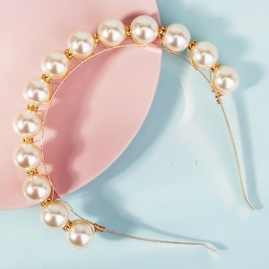 Elegant gold headband with large white pearls and crystal spacers on pink background