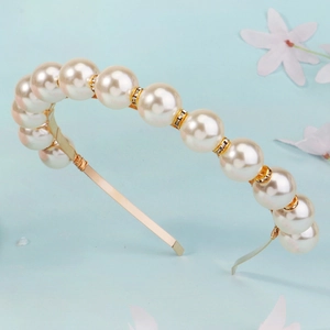 Close-up of handmade gold headband with large pearls and sparkling rhinestone accents