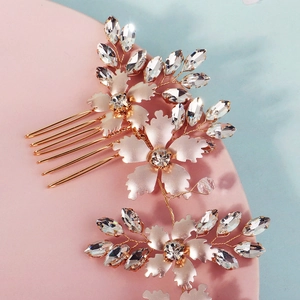 Detailed close-up of rose gold floral bridal hair comb with crystals and metal leaf