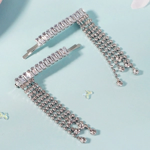 Set of two silver rhinestone tassel hair clips with cascading crystals on a blue surface