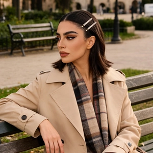 Primer plano de pasadores con brillantes en modelo con gabardina beige y bufanda