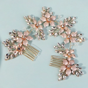 Close-up of rose gold floral bridal hair combs with sparkling rhinestones on blue background