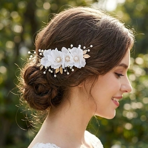 Macro shot of white fabric flowers and golden leaf wedding hair comb with pearls