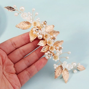 Handmade gold floral wedding hair clip with pearls and intricate leaf detailing