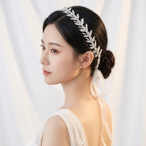 Dettaglio fascia per capelli da sposa con foglie di strass e nastro di raso bianco