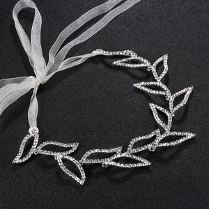 Dettaglio macro della fascia da sposa con foglie di strass argentati e nastro in organza