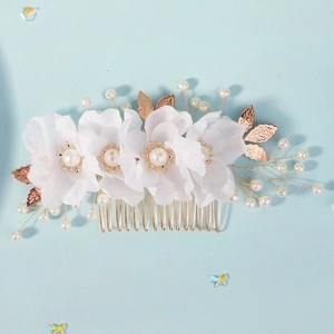 Detailed view of handmade bridal hair comb with fabric flowers and gold leaf accents