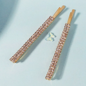 Detalle de horquillas de metal dorado con incrustaciones de strass y adorno de mariposa