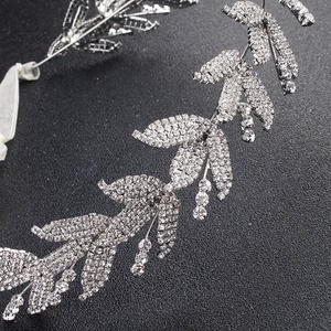 Dettaglio fascia da sposa con foglie argentate, strass scintillanti e nastro di seta