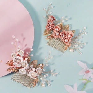 Pink and white floral bridal hair combs with pearls and gold leaves on light blue background