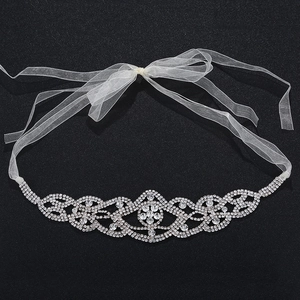 Dettaglio fascia da sposa con strass argentati e nastri in organza bianca raffinata