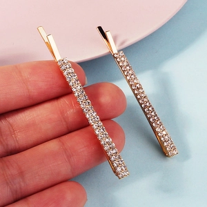 Primer plano de un par de pasadores dorados con brillantes diamantes de imitación