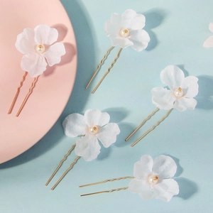 Detail of five-piece set bridal hair pins with white fabric flowers and ivory pearls