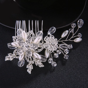 Detail of bridal hair comb with silver floral pattern, rhinestones and white pearls