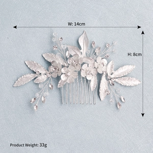 Macro shot of silver bridal hair comb featuring metal flowers and crystal details