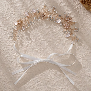 Détails d'un bandeau de mariée fait main avec perles blanches et fils métalliques dorés
