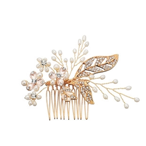 Macro detail of bridal hair comb with gold leaves, white pearls and sparkling crystals