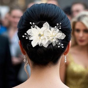 Détail du peigne de mariée avec fleurs en résille et perles sur chignon élégant