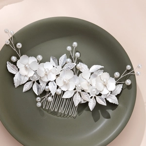 Exquisite bridal hair comb with white flowers, pearls, and silver leaves for wedding styling