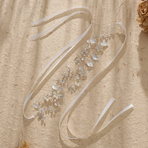 Serre-tête de mariée argenté avec perles, strass et feuilles sur un fond de ton chaud