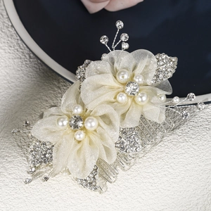 Détail d'un peigne à cheveux mariée avec fleurs en tulle, perles et cristaux brillants