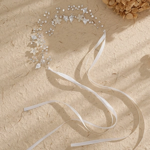 Détail d'un bandeau de mariée fait main avec perles, strass et rubans de satin