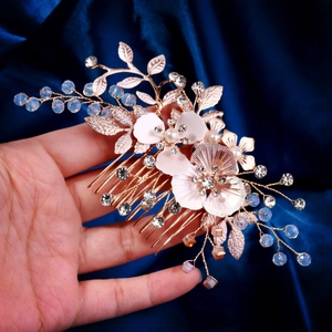 Détail d'un peigne à cheveux doré avec perles et fleurs en cristal pour la mariée