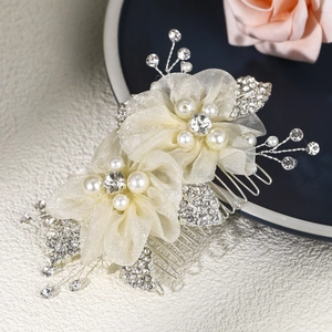 Détail d'un peigne de mariée avec fleurs en tulle champagne, perles et strass