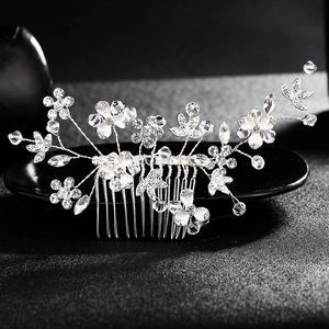 Détail d'un peigne de mariée avec fleurs argentées, perles et cristaux scintillants