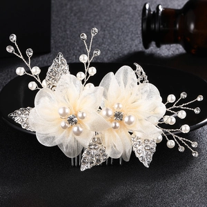 Détails de fleurs en tissu crème avec perles et cristaux sur un peigne à cheveux de mariée