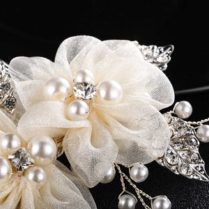 Détail macro du peigne de mariée avec fleurs en maille, perles et cristaux sur fond noir