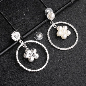 Detailed macro of golden starfish drop earrings with white pearls and rhinestones
