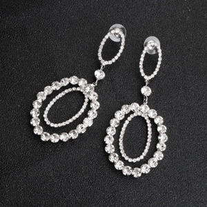 Detail of silver alloy rhinestone drop earrings featuring double oval nested design