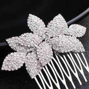 Detailaufnahme eines silbernen Brauthaarkamms mit floralen Mustern und weißen Glitzersteinen