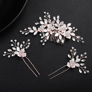 Dettaglio di forcine da sposa in oro rosa con fiori rosa, perle e strass brillanti